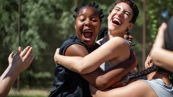 two-girls-celebrating-outdoor-activity-win-hugging